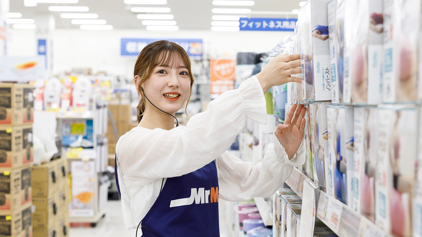 社員が棚に商品を並べている画像